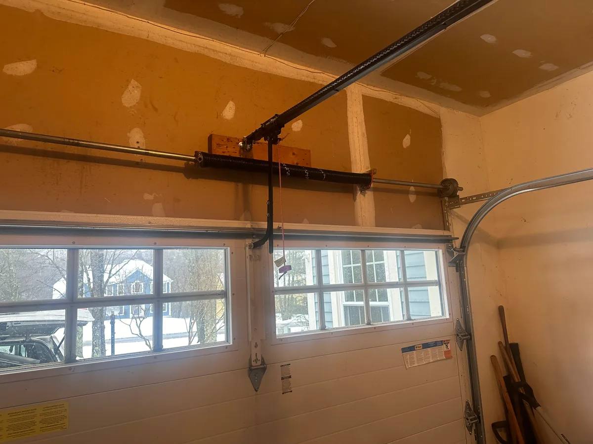 Residential garage door spring system and opener rail interior view with windows